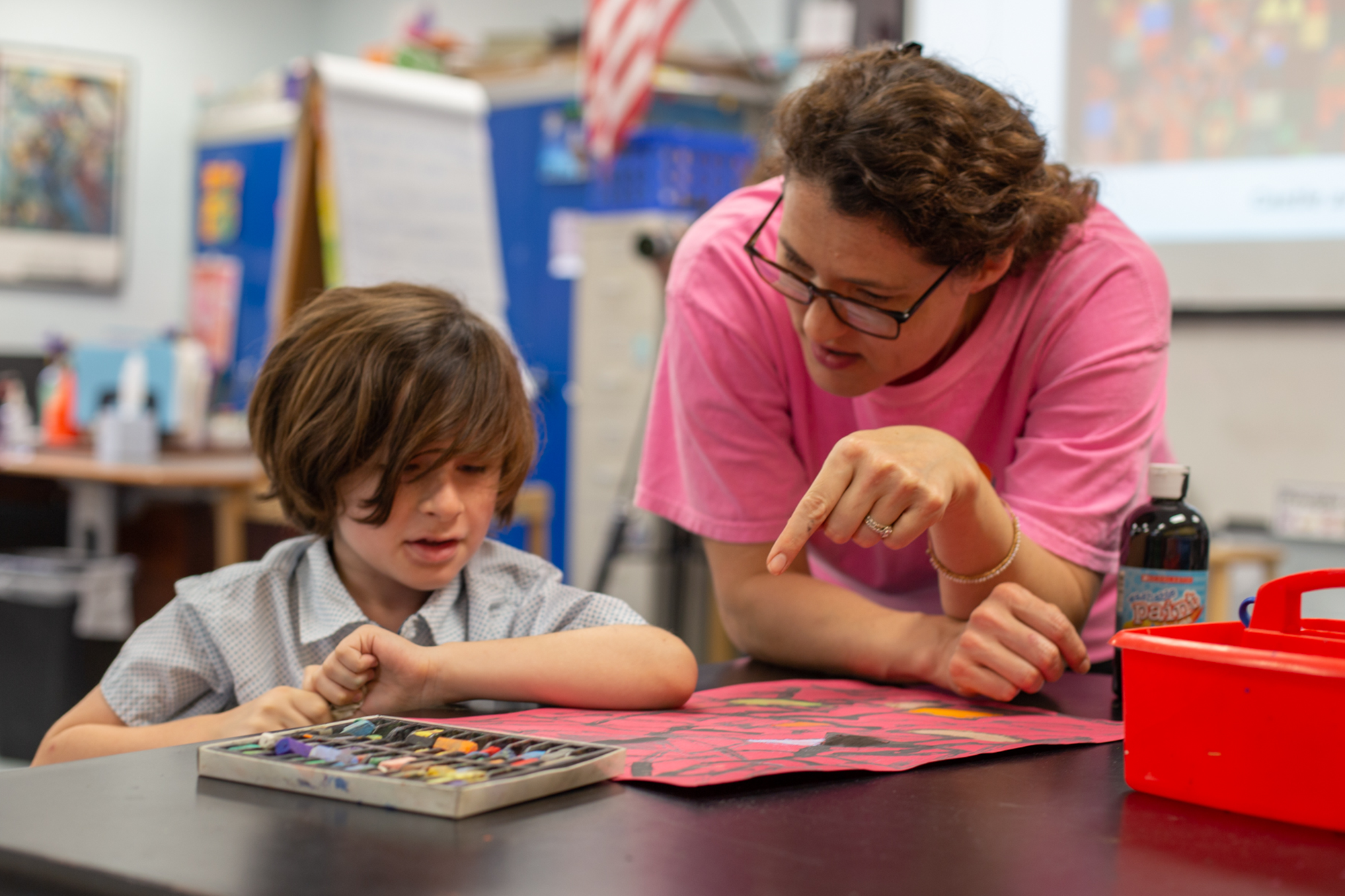 a teacher teaching a kid in art class